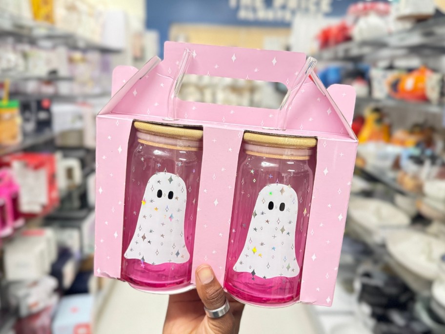 hand holding a box with 2 glass tumblers that are pink with ghosts on them