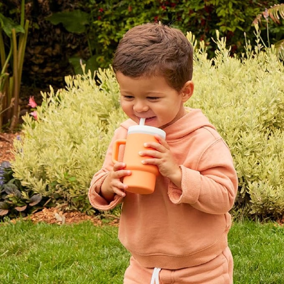 Toddler holding a My 1st Tumber in orange