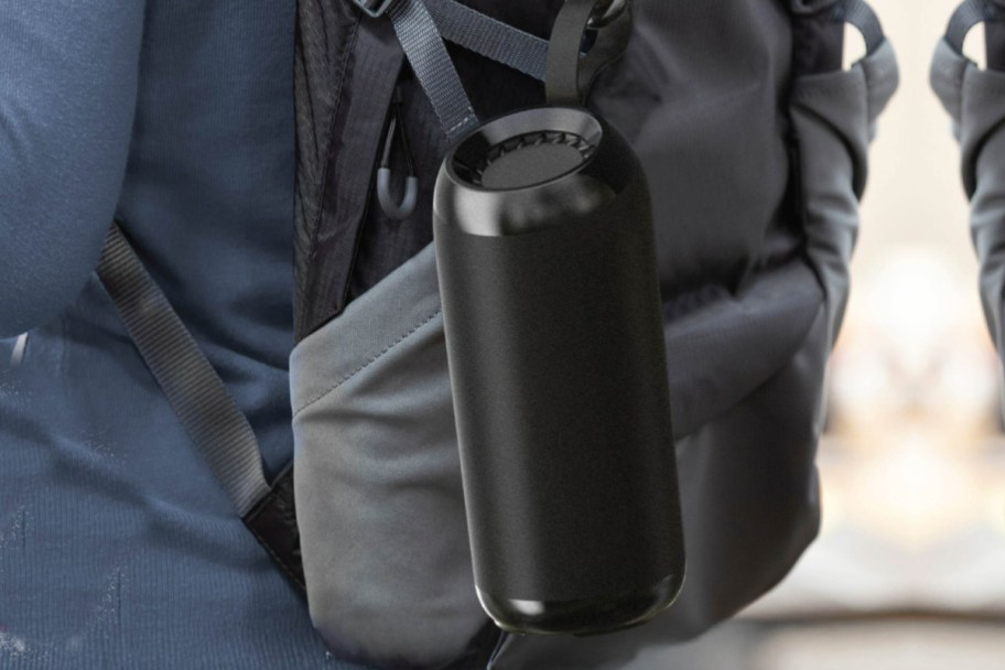 black portable speaker attached to backpack