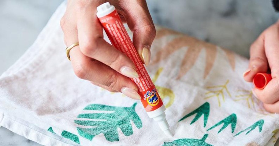 person using stain remover pen on fabric