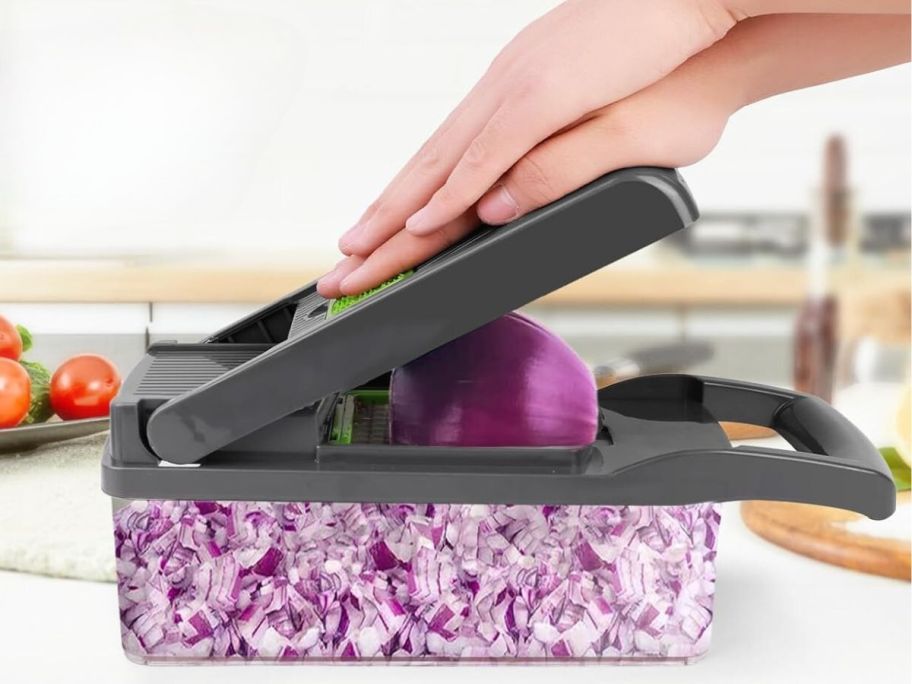 person using vegetable chopper to chop onion