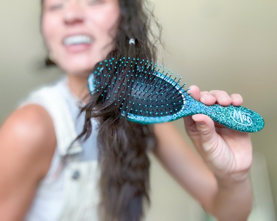 woman brushing hair with wet brush