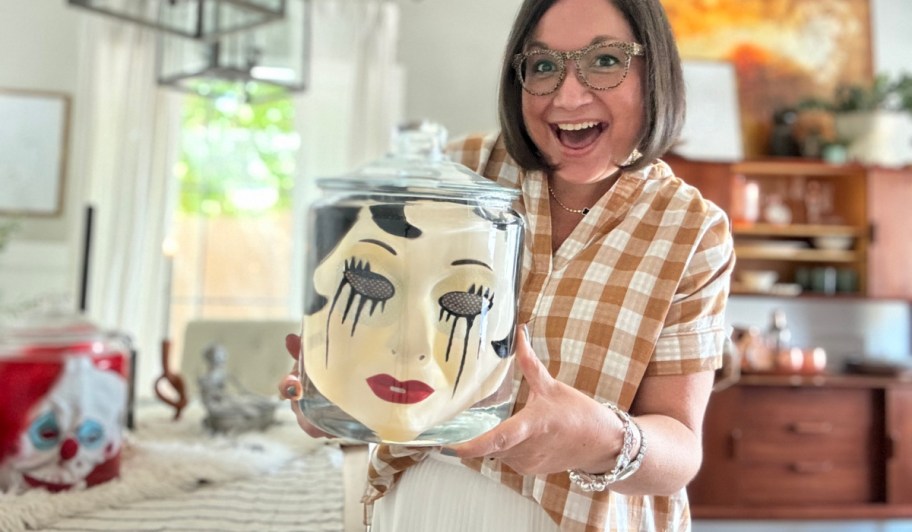 woman holding a face in a jar for halloween 