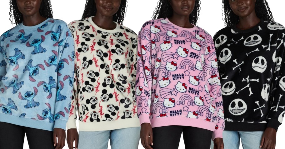 4 women wearing character sweatshirts, blue with Stitch, cream with Mickey Mouse, pink with Hello Kitty, and black with Jack Skellington