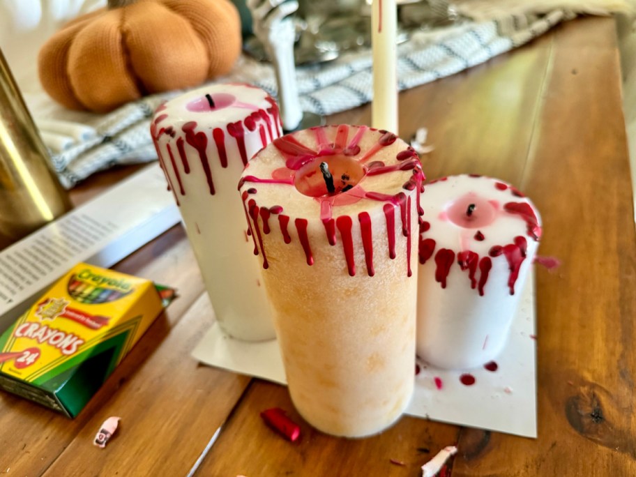 3 pillar candles with melted crayon to create bloody candles 