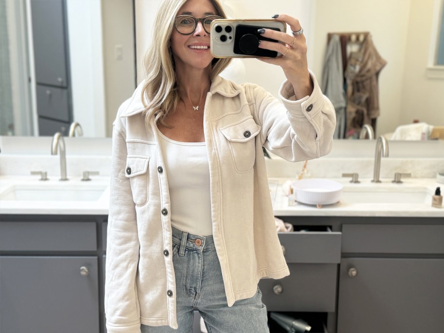 woman taking photo in mirror wearing a white shacket