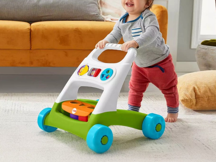 toddler baby pushing a fisher-price toy