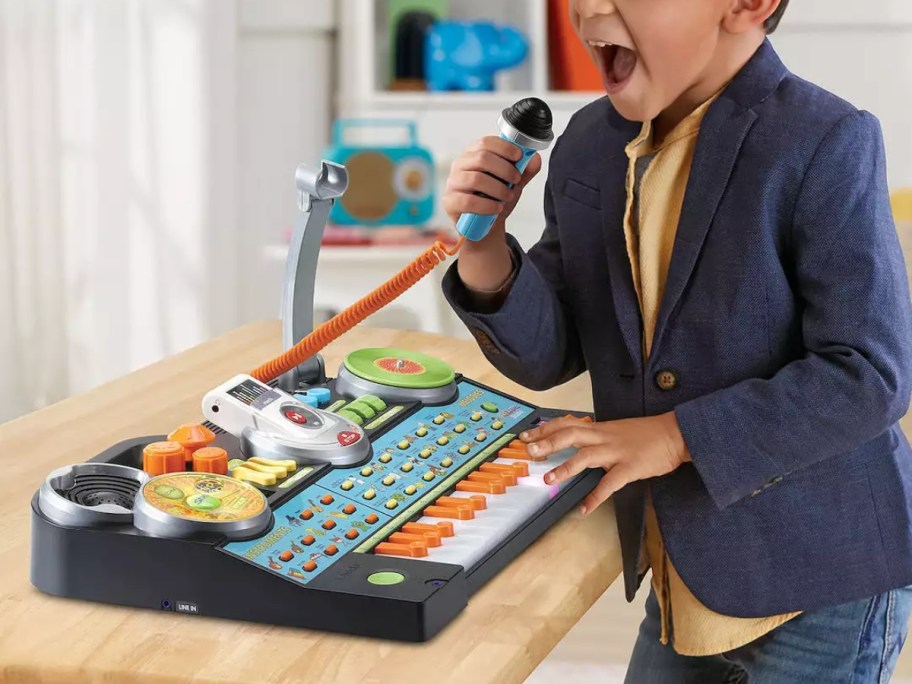 little boy playing with a VTech KidiJamz Studio keyboard with mic