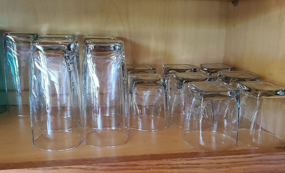 a 16 piece set of drinkware in a kitchen cabinet