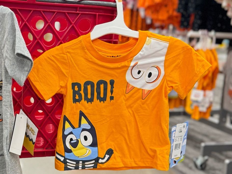 A Bluey Halloween Tee hanging from a Target shopping cart