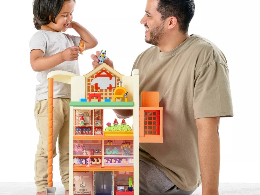 toddler and a man playing with a Bluey Hammerbarn Shopping Playset