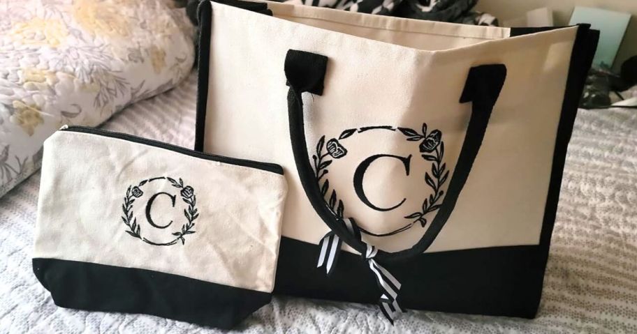 A canvas tote bag with a matching makeup bag on a bed