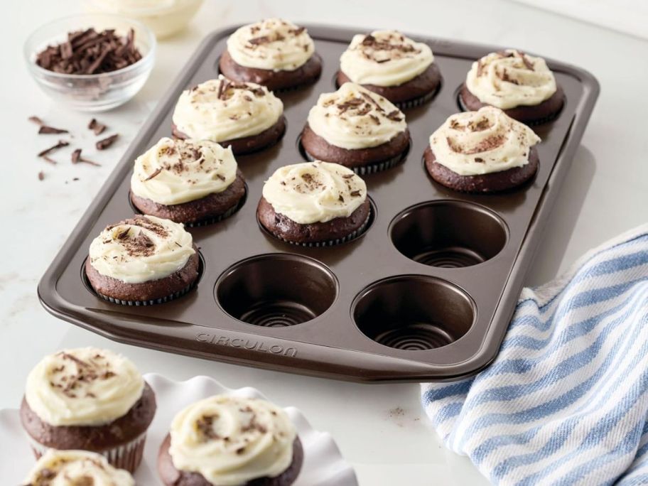 Circulon Nonstick Bakeware 12-Cup Muffin Tin on kitchen counter with iced cupcakes inside it