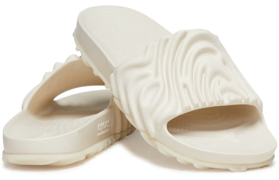 pair of cream color adults Crocs slides with a ridged, rippled, swirl type design