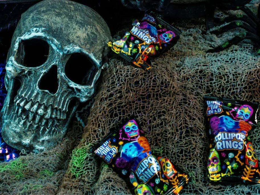 A fake skull next to bags of Flix Day of the Dead Loliipop Rings