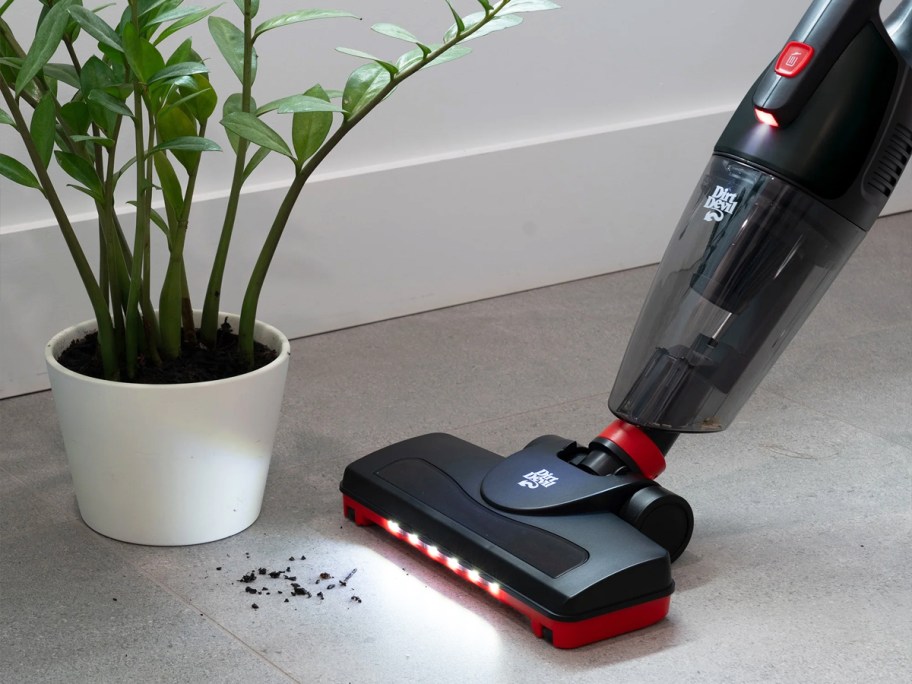 dirt devil vacuum cleaning up dir near potted plant
