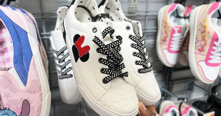 hand touching a pair of minnie mouse sneakers