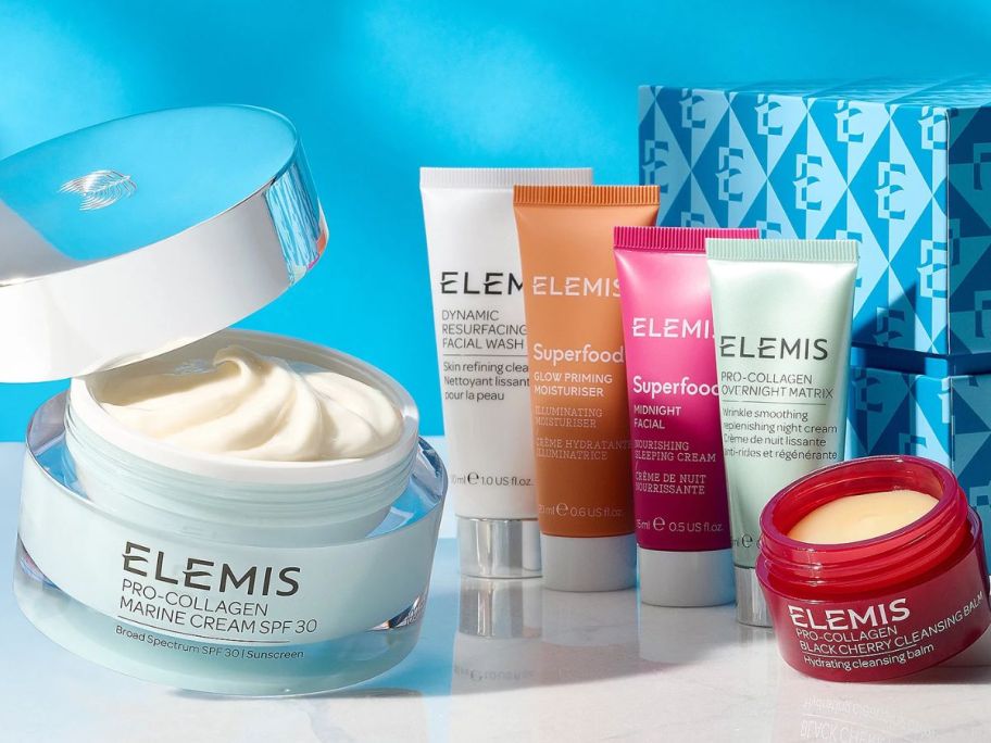Image of an open Elemis Pro-Collagen Marine Cream next to 5 other Elemis skincare products