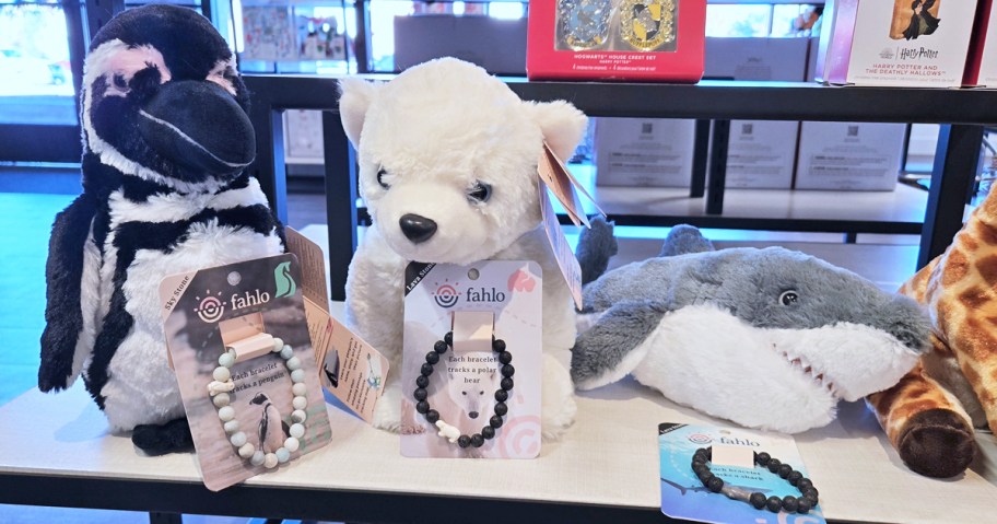 animal bracelets and stuffed animals on store display table