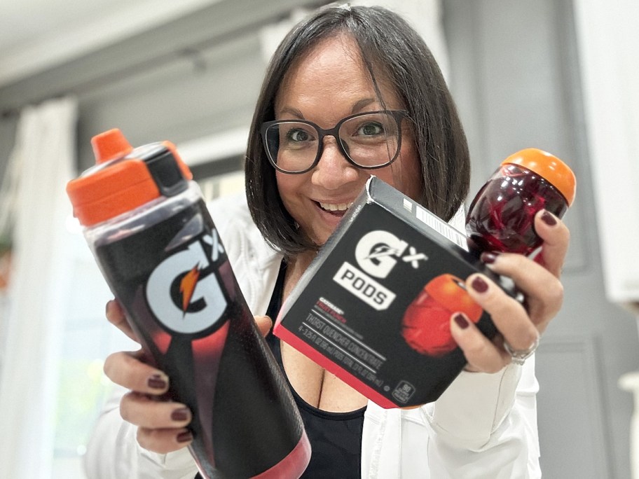 woman holding up gatorade pods and bottle