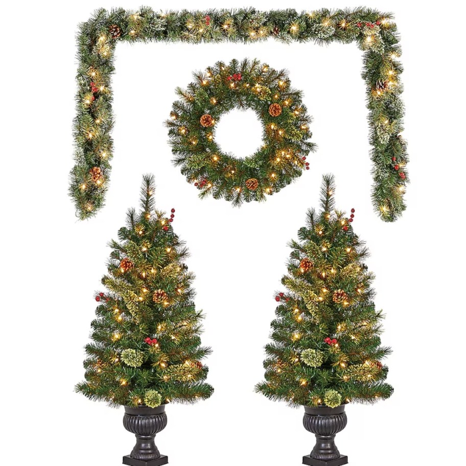 a set of 2 small Christmas trees in brown planters, matching wreath and garland all pre-lit