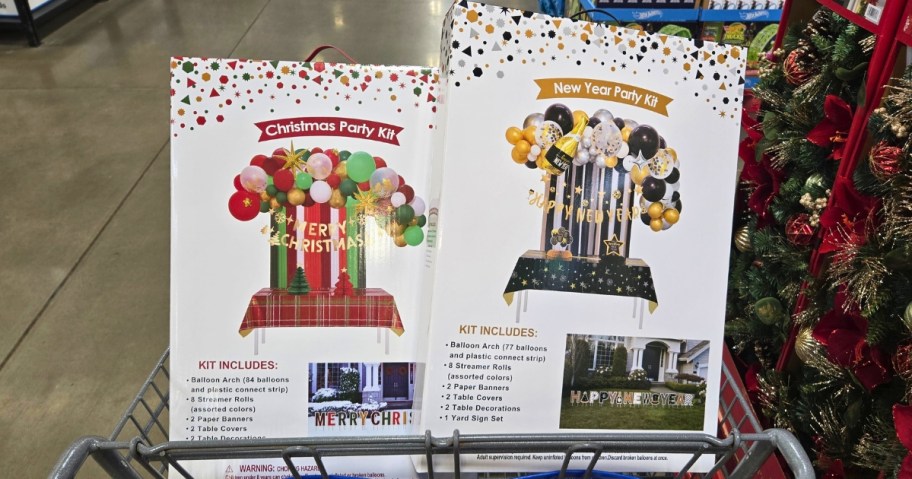 a Sam's Club shopping cart with red and green holiday and black and gold New Year's party decorating kit boxes in it 