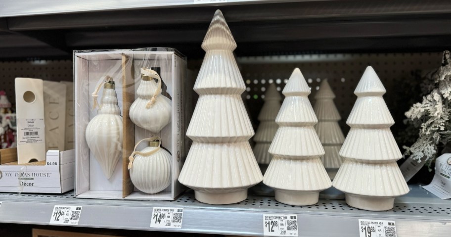 ceramic cream color Christmas ornaments in a box and cream color ceramic Christmas trees on a store shelf