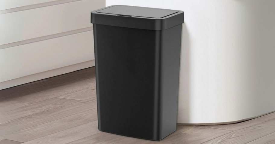 a black 13 gallon kitchen size trash can in a kitchen against a white island