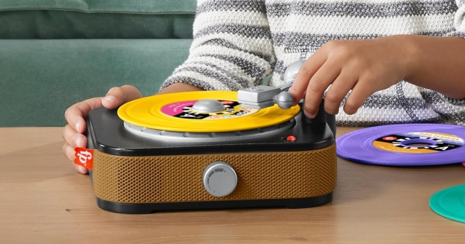 kids hands playing with a toy record player