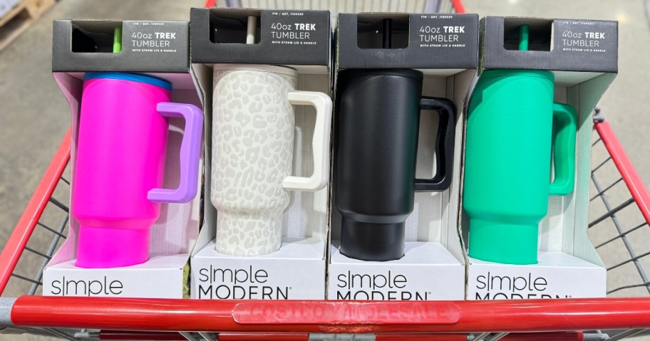 a Costco shopping cart with 4 different color Simple Modern 40oz Trek Tumblers in their packaging