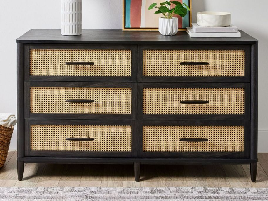 a black wood dresser with caning on the drawers