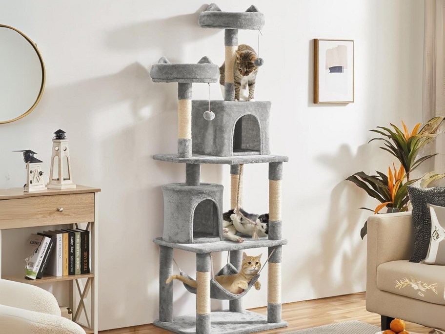 a tall grey and white cat tree in a living room with cats on it