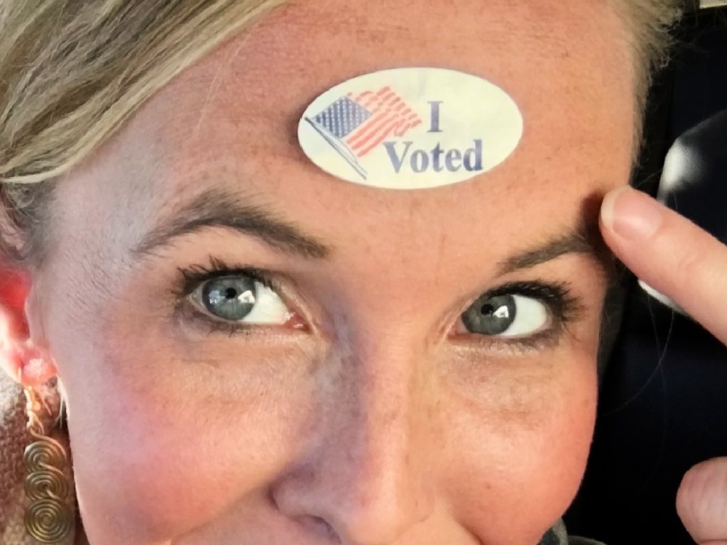 woman wearing i voted sticker on forehead