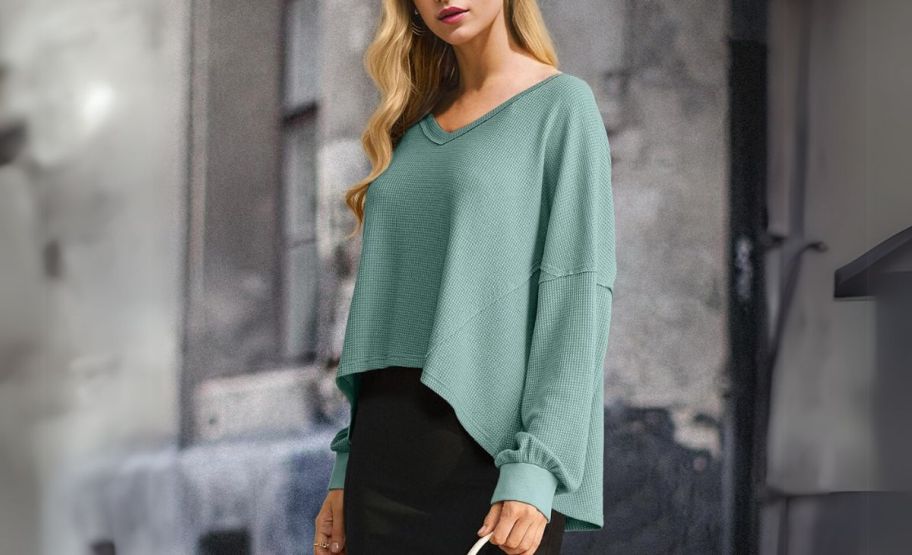 a woman in a green waffle knit hi-low hemmed top 