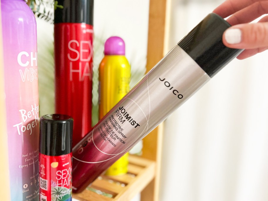 hand grabbing a can of Joico Hair Spray from shelf