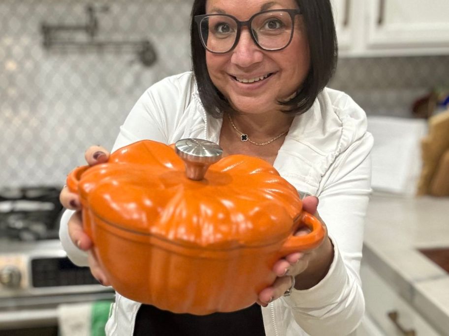 Woman holding a pumpkin shaped casserole dish