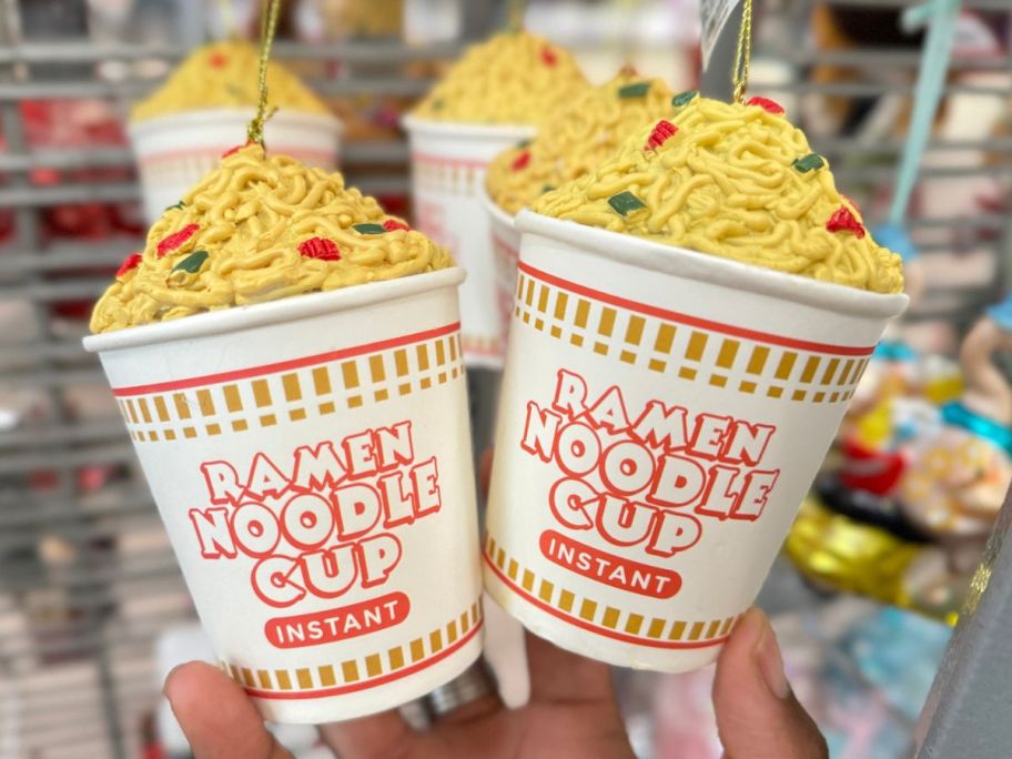 Hand holding two Kurt Adler Ramen Noodle Cup Christmas Ornaments