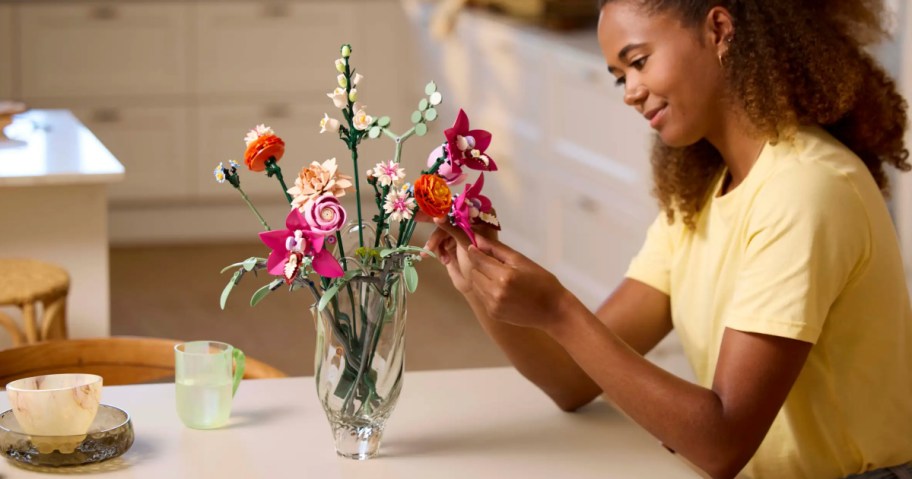 woman building LEGO Botanicals Pretty Pink Flower Bouquet