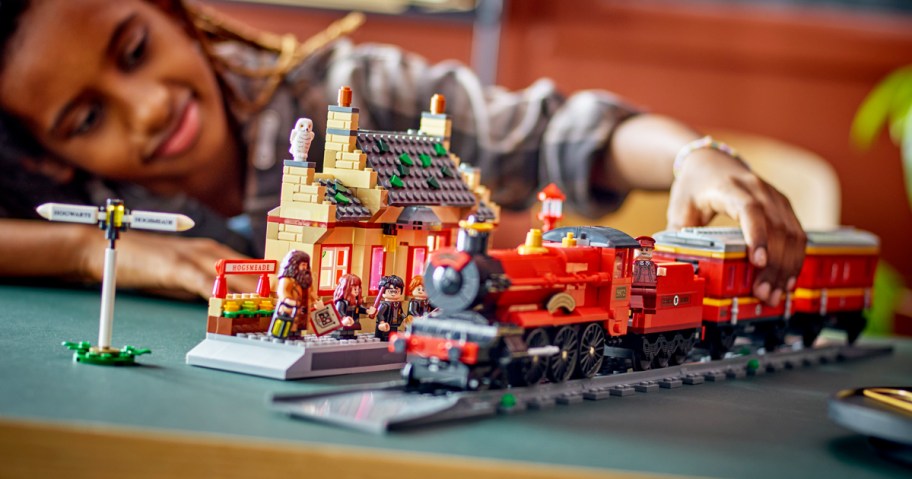 boy playing with LEGO Harry Potter Hogwarts Express & Hogsmeade Station Building Set