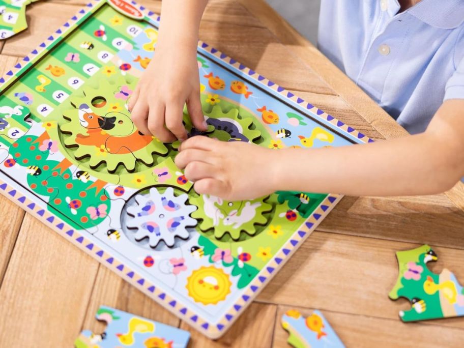 kid playing with Melissa & Doug Wooden Animal Chase Jigsaw Spinning Gear Puzzle on table