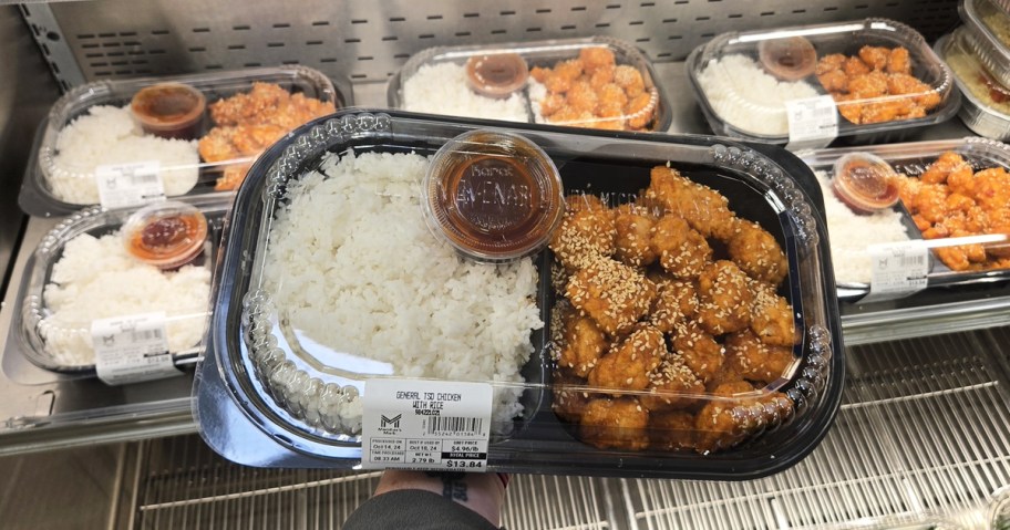 hand holding up a container of Members Mark General Tso Chicken with Jasmine Rice