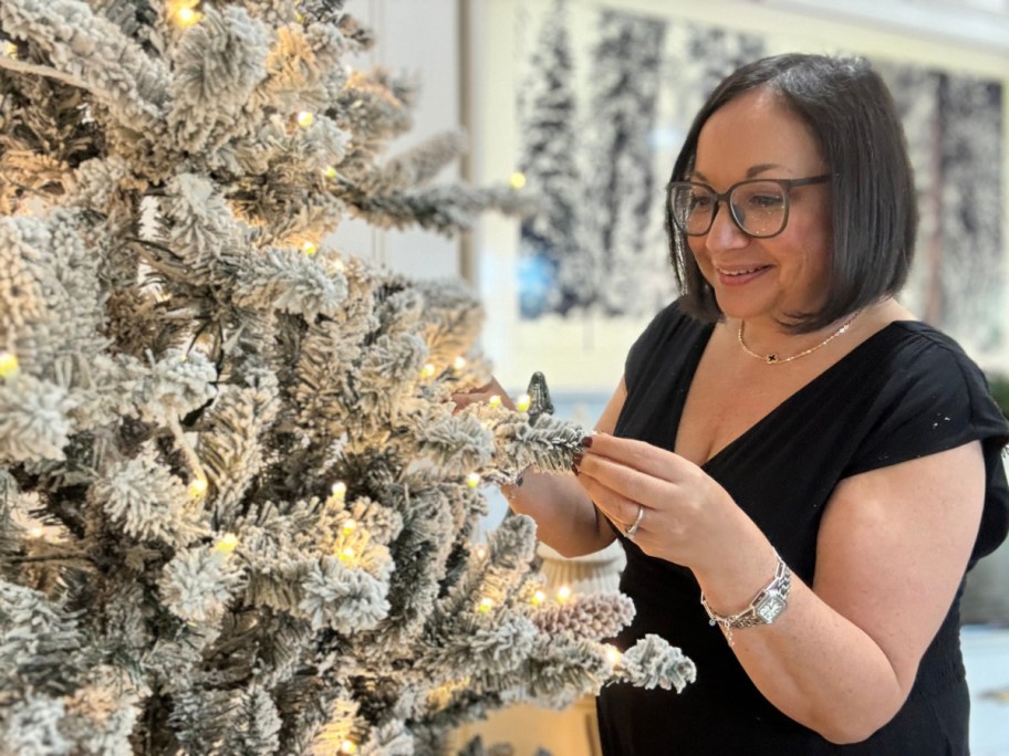 Woman admiring her flocked Christmas tree from Walmart's 2024 holiday collection