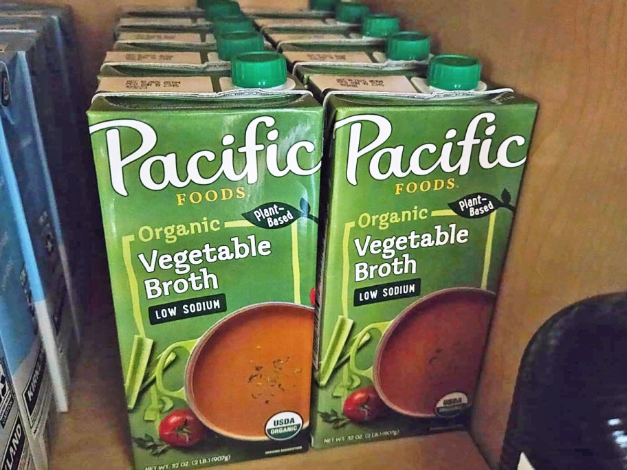 multiple green cartons of Pacific Foods Organic Low Sodium Vegetable Broth in cabinet