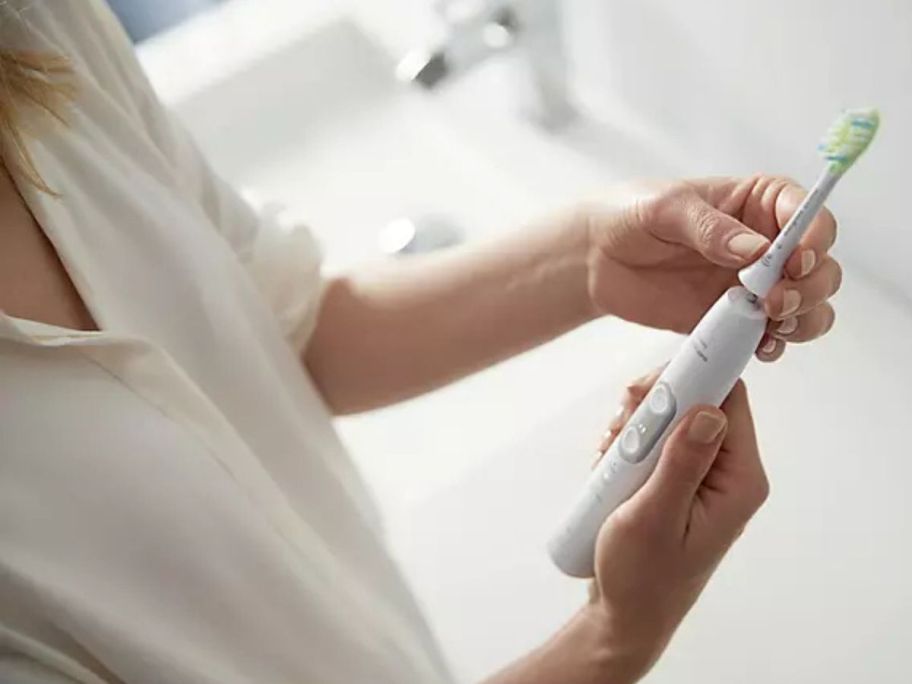 Woman adjusting a Philips Sonicare 6100 ProtectiveClean Power Toothbrush 