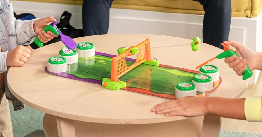 two kids playing Pickleball Blast Game on coffee table