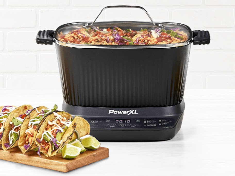 PowerXL StirMax 7.5-Quart Multi-Cooker with taco meat inside and tacos in front of it