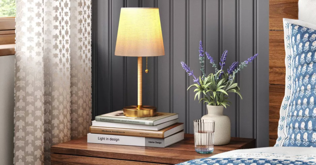 Rattan Table Lamp on top of books on bedside table