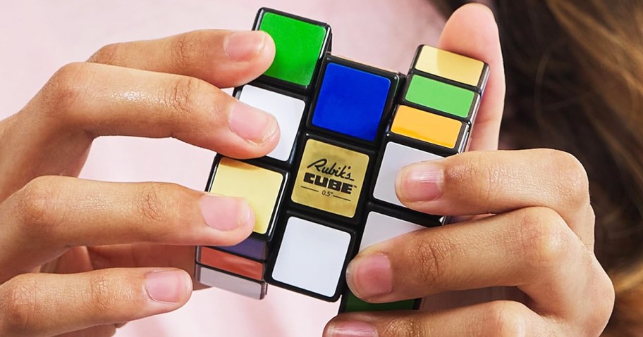 hands holding a Rubik’s Cube puzzle