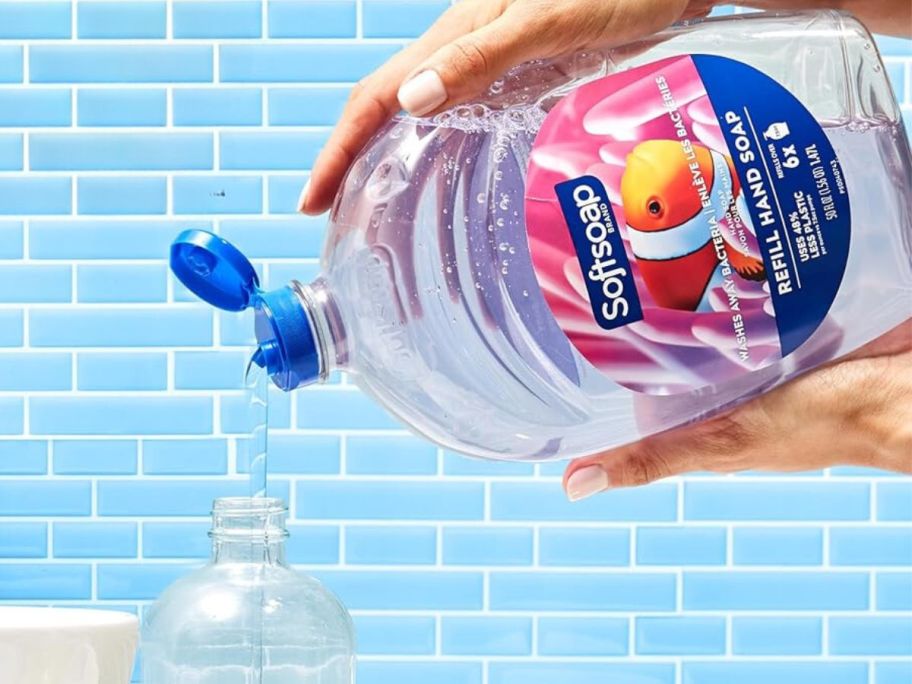 A person filling a bottle with Softsoap liquid soap