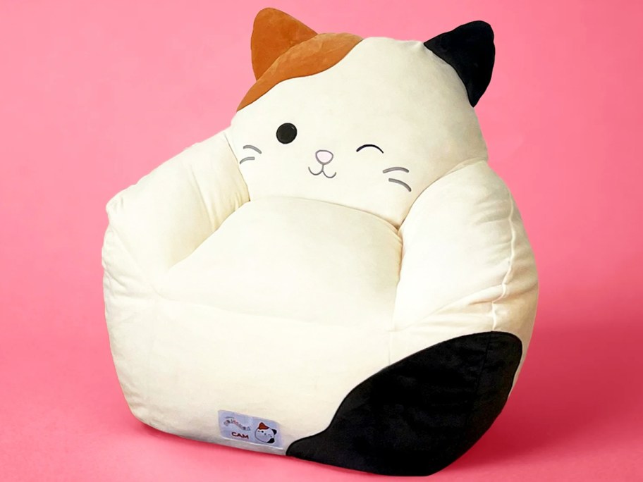 calico cat bean bag chair on pink background